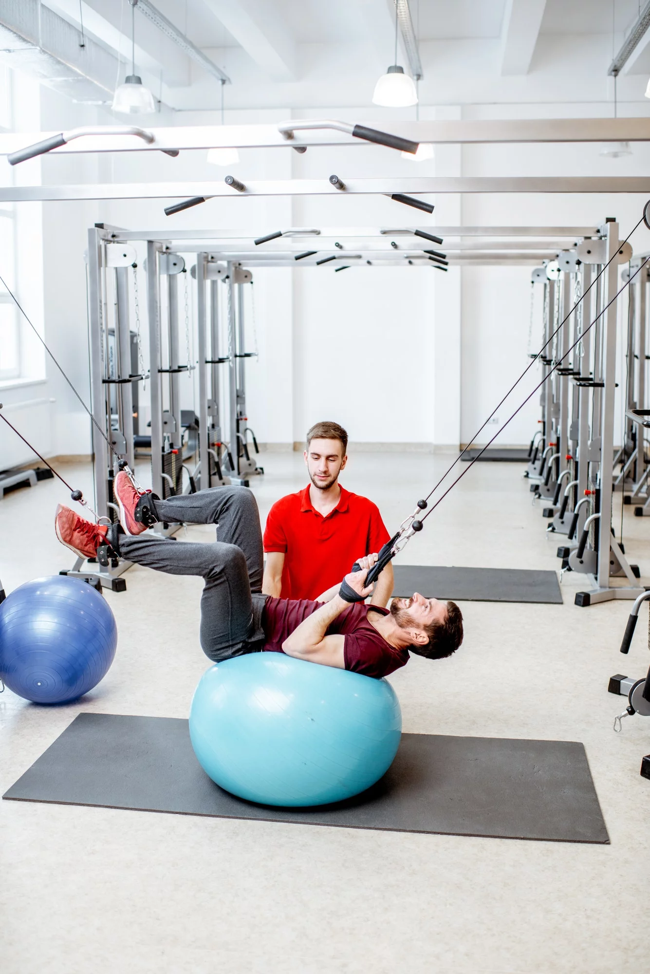 Man exercising with trainer at the rehabilitaion gym