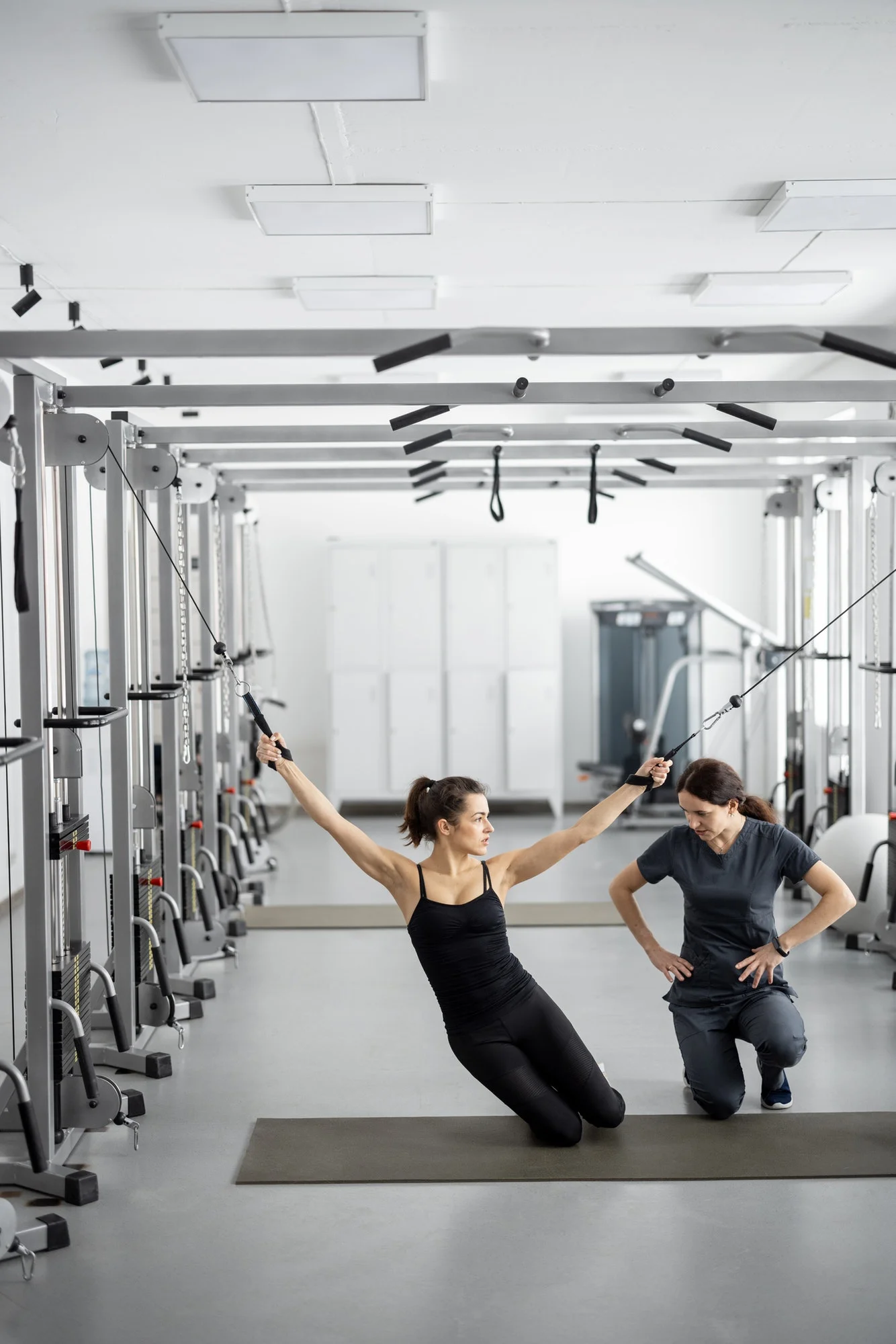 Woman doing exercises on decompression simulators with the help of rehabilitation specialist