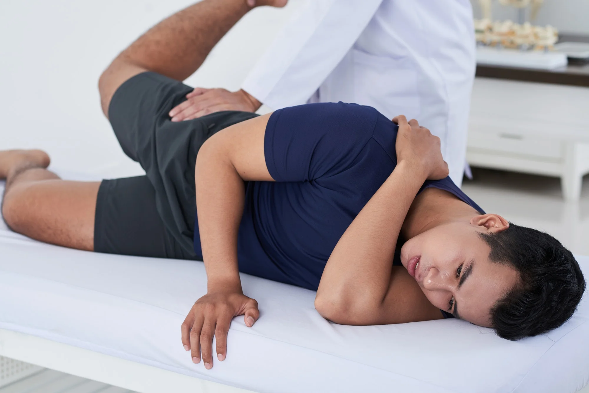 Young Man Getting Physiotherapy At Clinic
