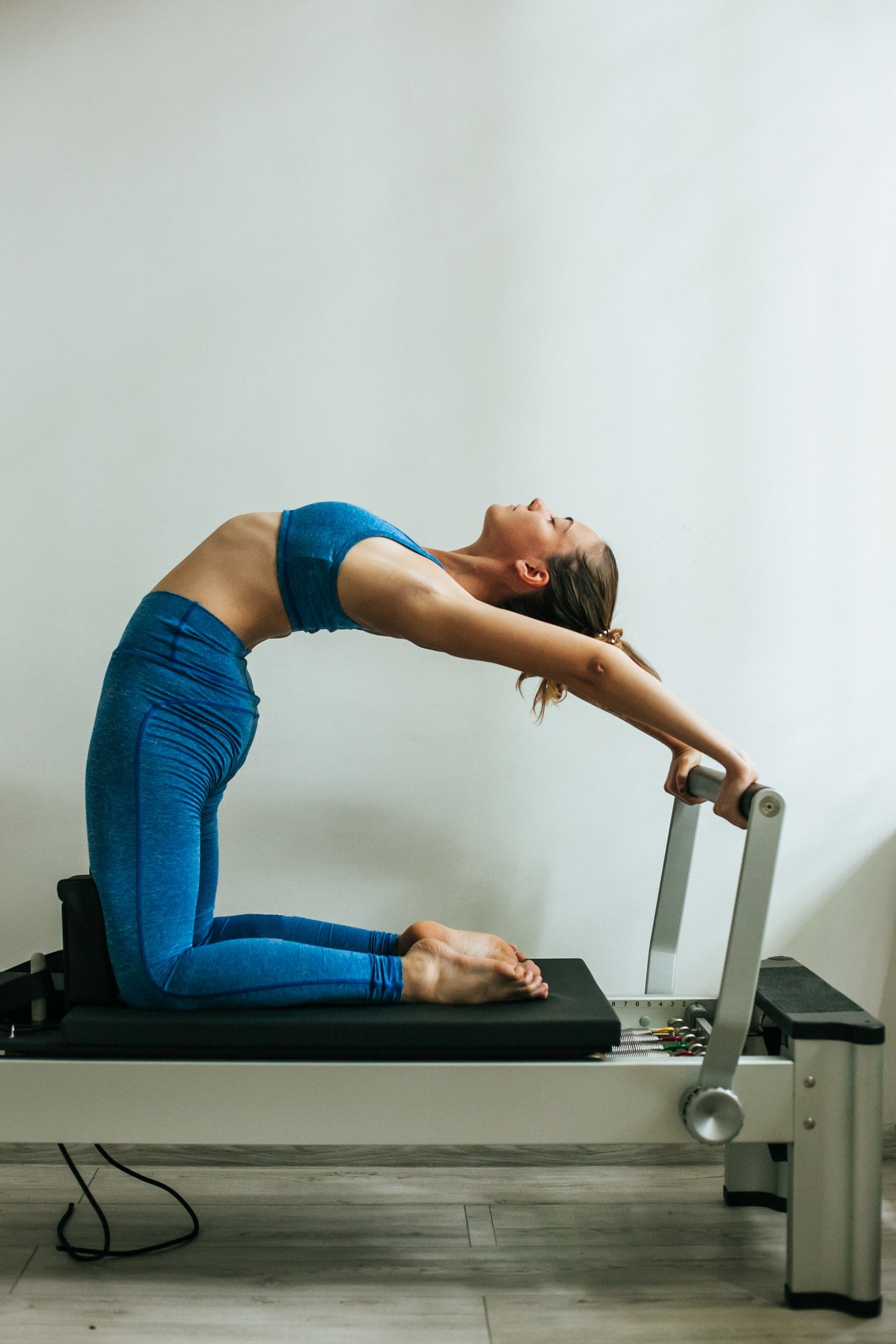 Woman performing Pilates exercise using a Cadillac or Trapeze table